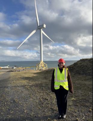 IDCORE Research Engineer - Maria Ahmad Maria standing in front of a wind turbine