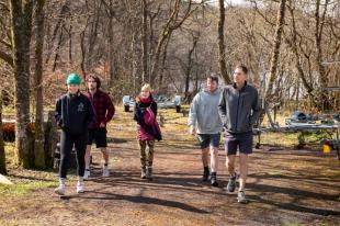 Group shot of IDCORE students walking through woods