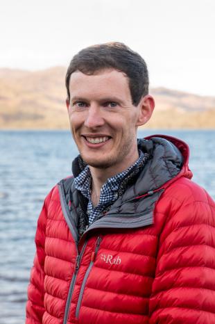 Jonathan Glasspool headshot, weating red bubble jacket