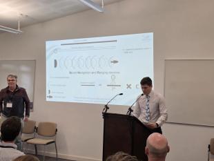 Thomas presenting behind a lecturn