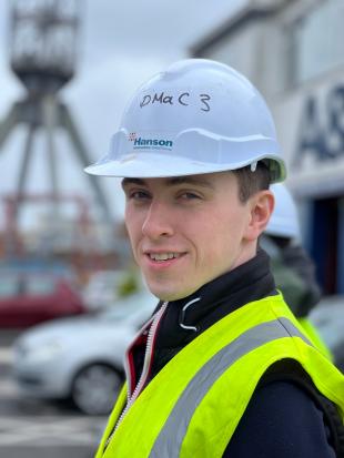 headshot of Simon McLaughlin weating hard hat and high viz vest, looking towards camera